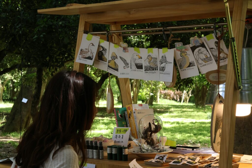 A woman shops at an outdoor art booth.