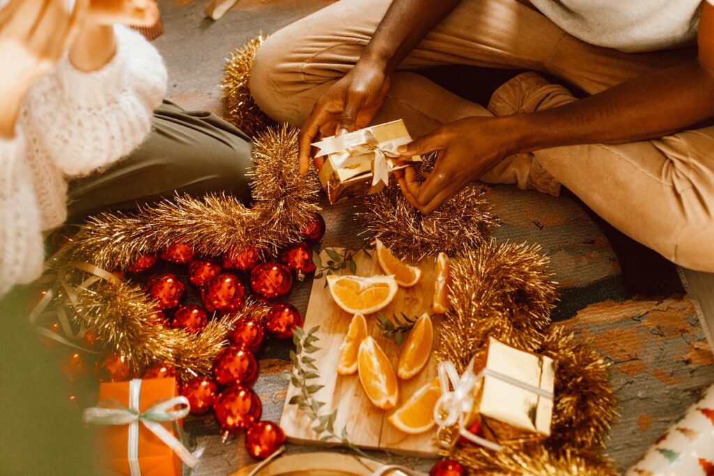 Warm holiday scene with decorations, oranges, and gift wrapping, perfect for festive themes.