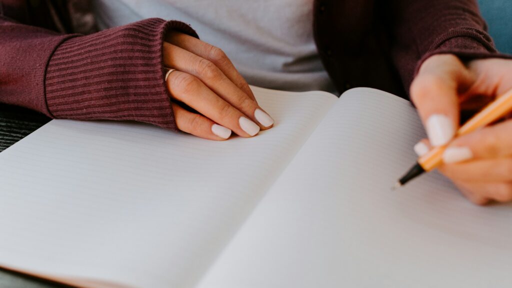 Person writing on white paper.