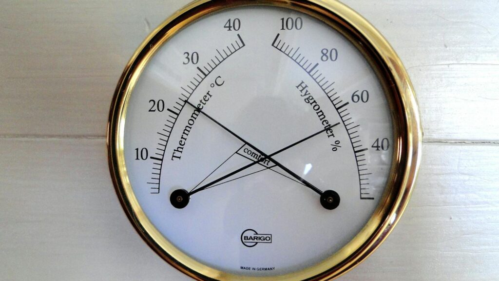 Close-up of a round analog display showing temperature and humidity.