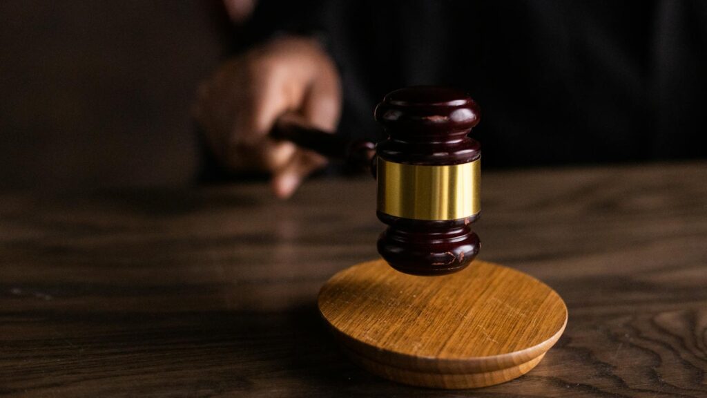 A gavel striking a sound block, symbolizing justice and legal authority in a courtroom setting.