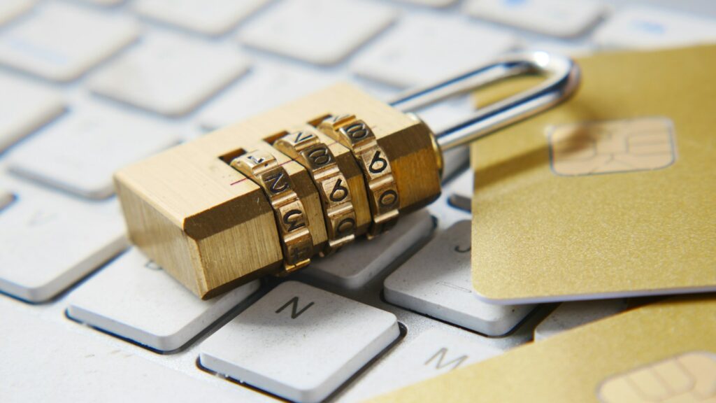 A golden combination padlock sitting on top of a keyboard.