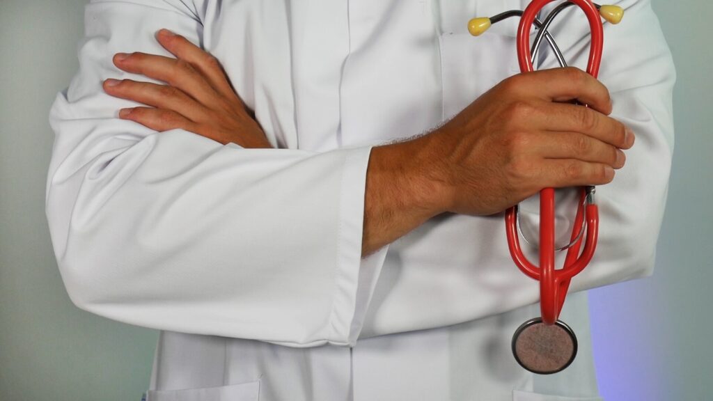 Medical professional wearing a white lab coat and holding a stethoscope.