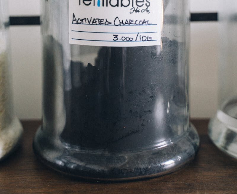 Close-up of refillable activated charcoal in a labeled glass jar for eco-friendly use.