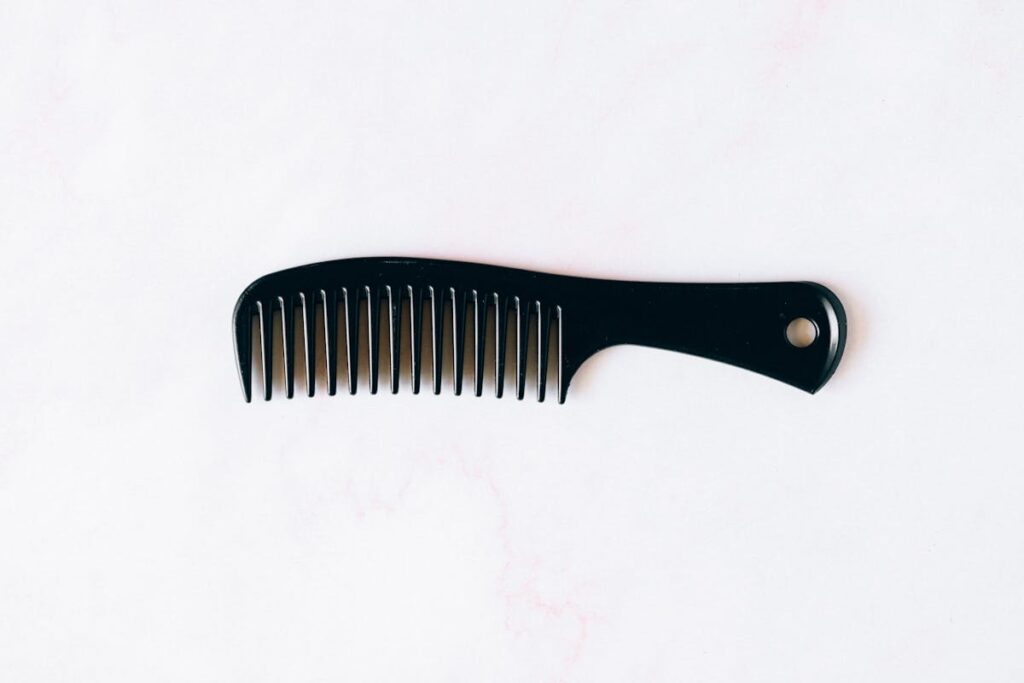 Close-up image of a sleek black comb isolated on a white background.
